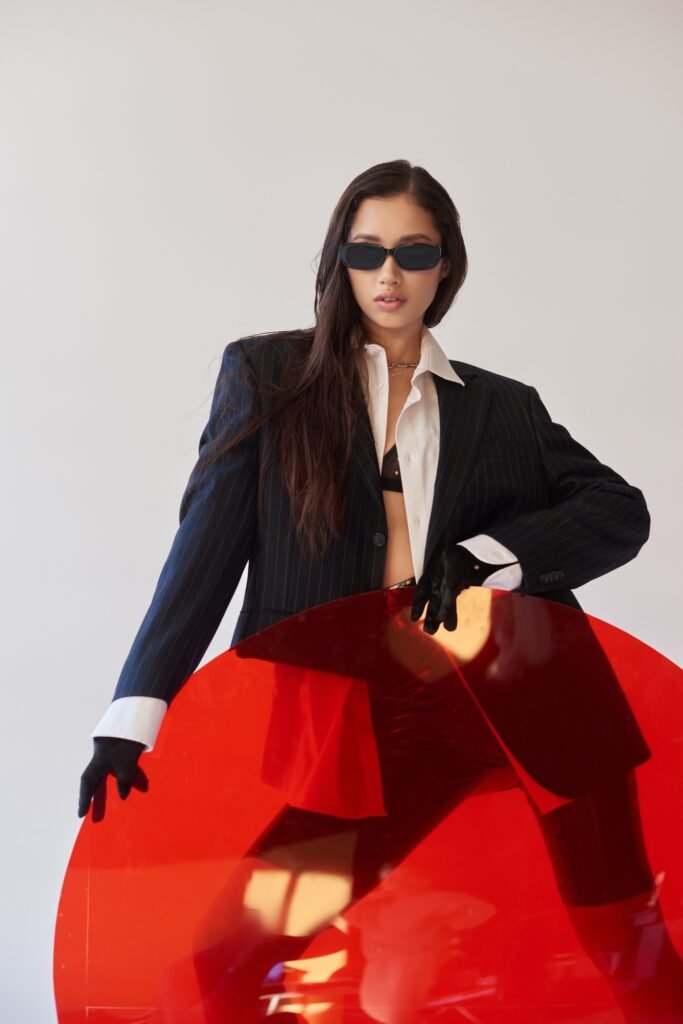 fashion forward, studio photography, young asian model in stylish look and sunglasses posing near