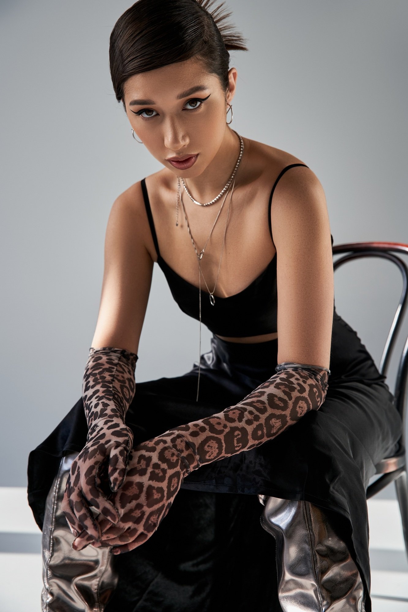 spring fashion photography, asian woman with expressive gaze, in animal print gloves, black strap